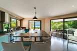 This stunning kitchen boasts a modern design with sleek turquoise cabinetry and a luxurious marble countertop island.