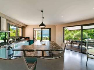 This stunning kitchen boasts a modern design with sleek turquoise cabinetry and a luxurious marble countertop island.