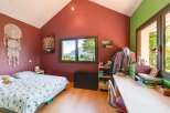 This charming bedroom boasts a cozy atmosphere with its inviting decor and natural light.