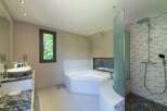 This luxurious bathroom boasts a modern design with a corner bathtub and a separate shower area.