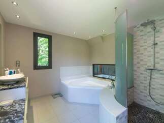 This luxurious bathroom boasts a modern design with a corner bathtub and a separate shower area.