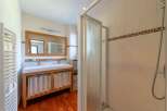 Step into this beautifully designed bathroom, featuring a spacious vanity with a wooden frame and elegant curtains.