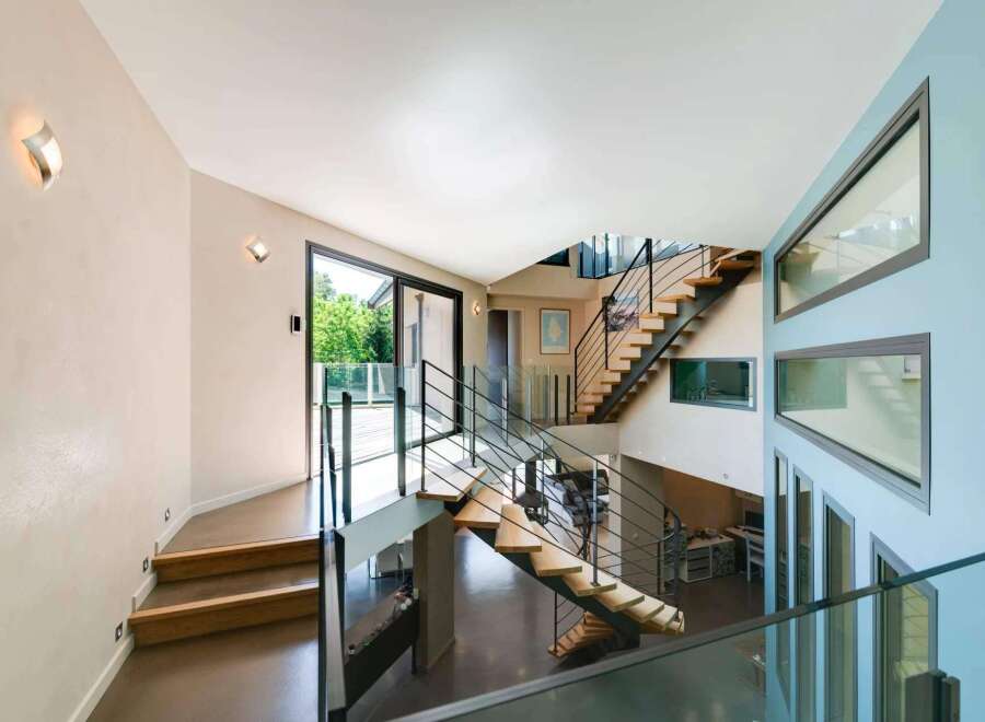 This stunning property boasts a modern architectural design with a grand staircase as its centerpiece.