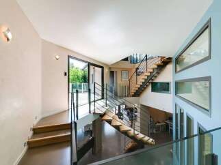 This stunning property boasts a modern architectural design with a grand staircase as its centerpiece.
