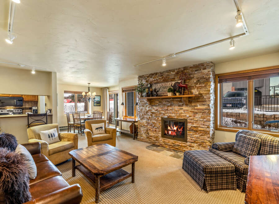 Experience the warmth of this inviting living space, featuring a stunning stone fireplace and cozy seating.