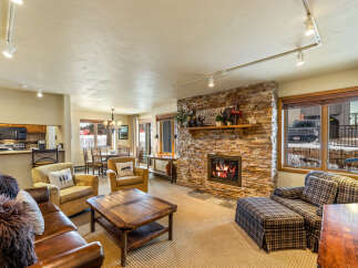 Experience the warmth of this inviting living space, featuring a stunning stone fireplace and cozy seating.