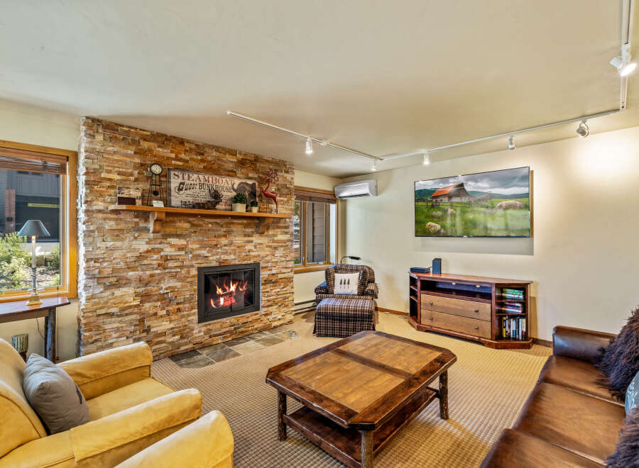 This cozy living room features a stunning stone fireplace, perfect for those chilly evenings.