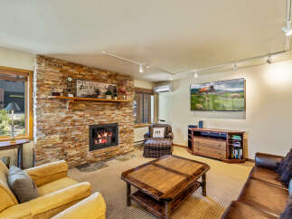 This cozy living room features a stunning stone fireplace, perfect for those chilly evenings.