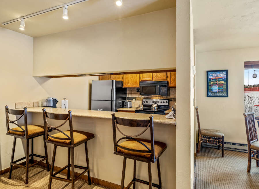 This charming kitchen features a breakfast bar with stylish bar stools, perfect for casual dining or entertaining.