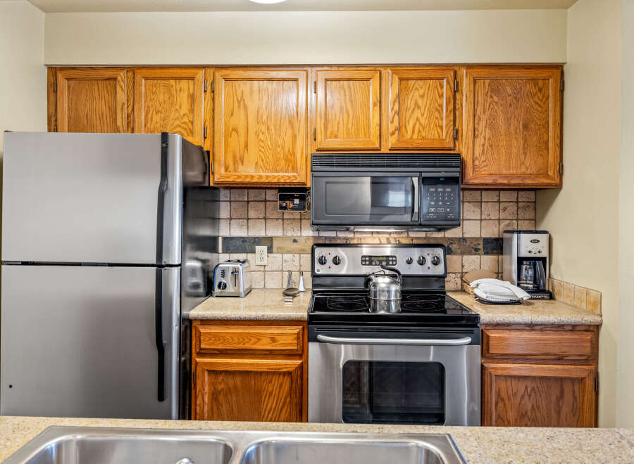 This kitchen features stainless steel appliances, including a refrigerator, stove, and microwave, offering a modern and functional space.