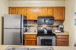 This kitchen features stainless steel appliances, including a refrigerator, stove, and microwave, offering a modern and functional space.