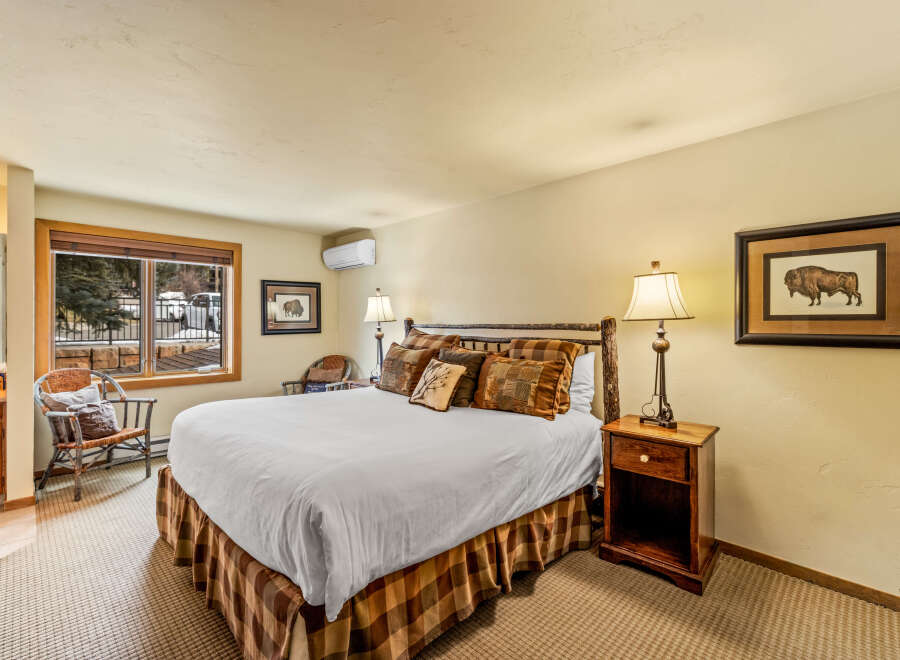 Step into this inviting bedroom, featuring a cozy bed adorned with plush pillows and a rustic wooden frame.