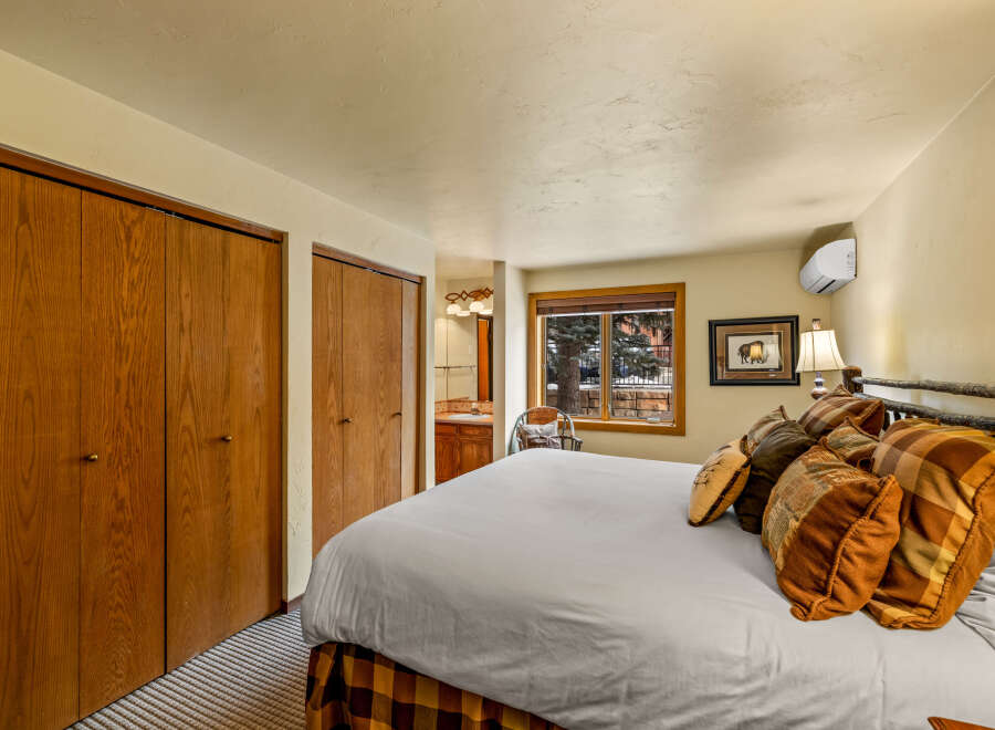 This cozy bedroom features a comfortable bed with decorative pillows, perfect for a relaxing retreat.