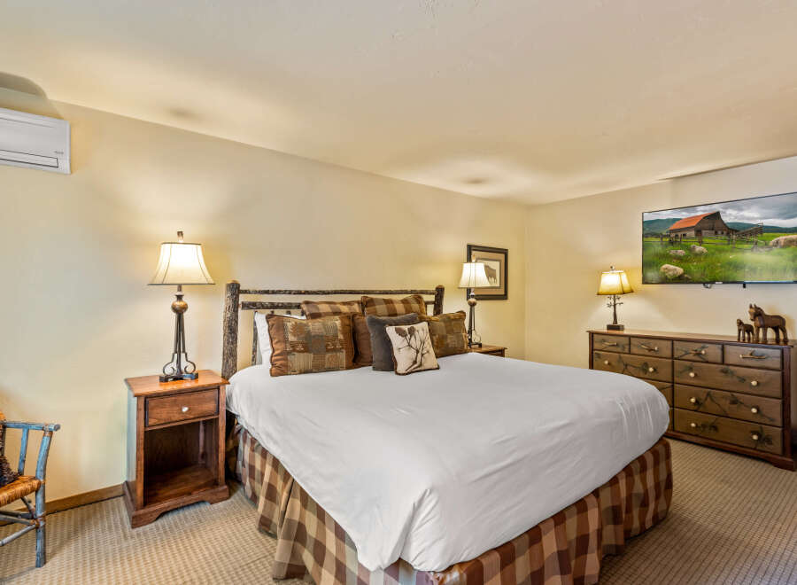 This cozy bedroom features a comfortable king-size bed with decorative pillows and a rustic wooden headboard.