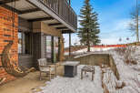 Enjoy the serene beauty of this property with its inviting outdoor seating area, perfect for relaxing in the winter wonderland.