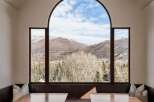 This stunning dining area boasts breathtaking mountain views through a large arched window.
