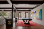 This stunning property features a luxurious game room with a pool table and a vibrant red rug, perfect for entertaining.
