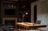 This luxurious home office boasts a sophisticated design with a dark wood ceiling and built-in shelving.