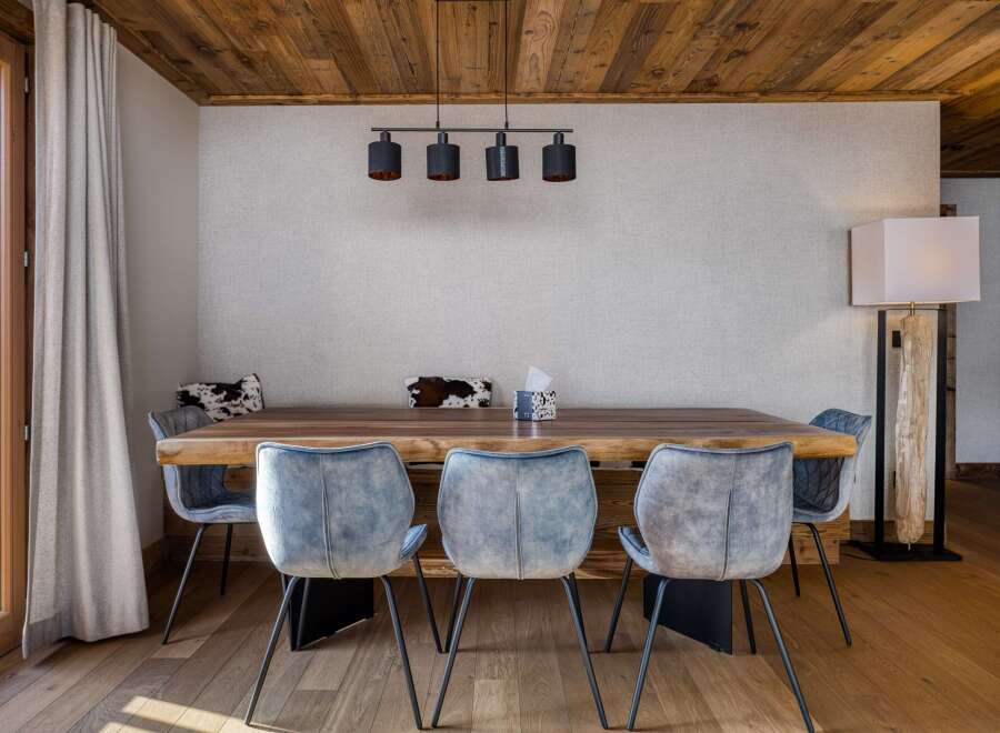 This stunning dining area features a beautiful wooden table and stylish blue chairs, creating a warm and inviting atmosphere.