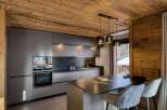 This stunning kitchen boasts a modern design with sleek, gray cabinetry and a contrasting wooden ceiling, creating a warm and inviting atmosphere.