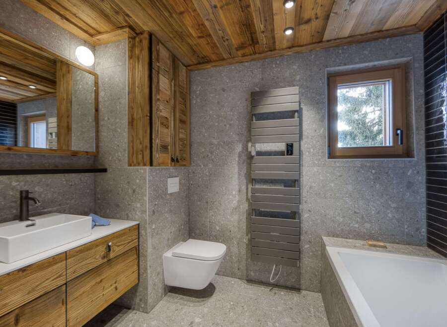 This stunning bathroom features a rustic design with wooden accents and modern amenities.