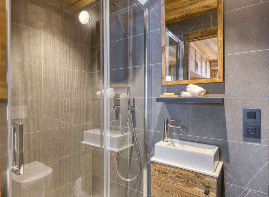 Step into luxury with this stunning bathroom, featuring a sleek glass shower and modern fixtures.