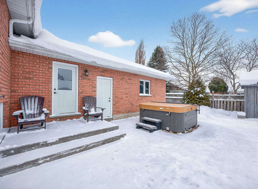 Enjoy the winter wonderland from the comfort of your own backyard! This property features a cozy outdoor space with a hot tub, perfect for relaxing after a long day.