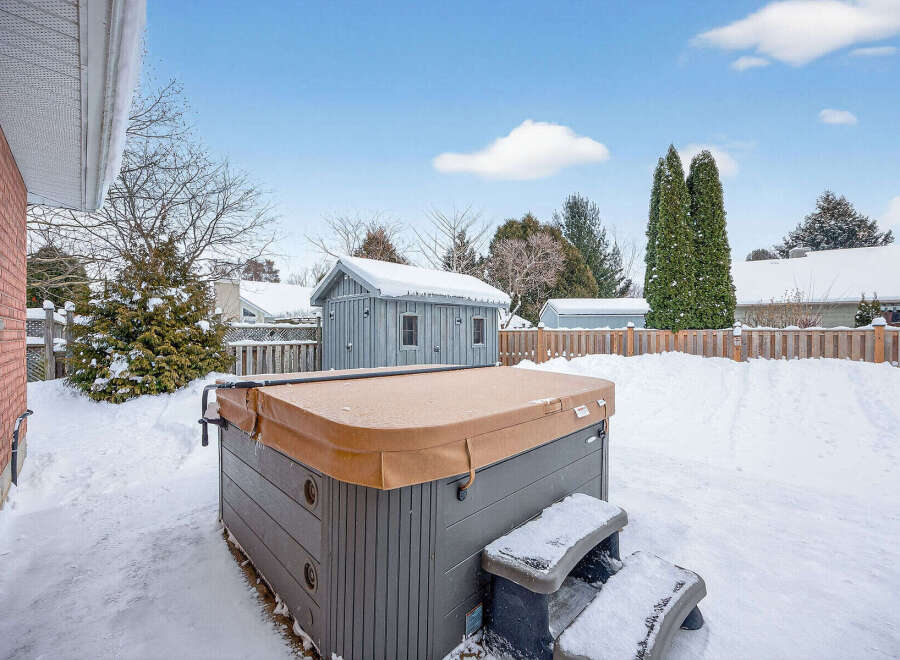 Enjoy the tranquility of this backyard oasis, complete with a hot tub, perfect for relaxing after a long day.