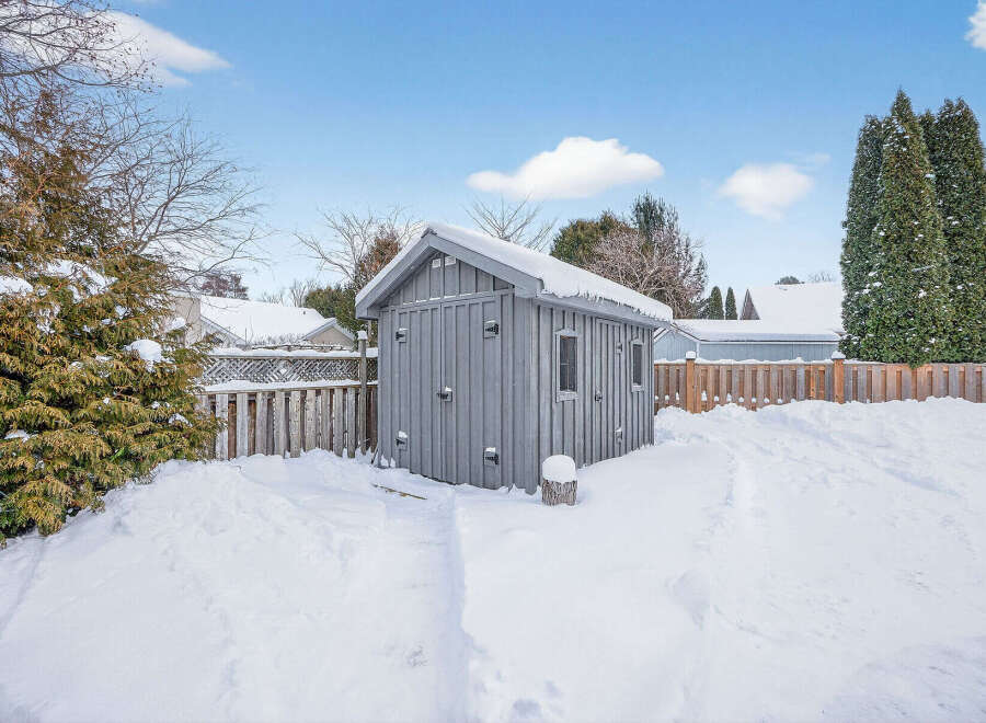 This charming property features a cozy shed nestled in a snow-covered backyard, perfect for storage or a workshop.