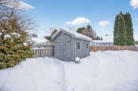 This charming property features a cozy shed nestled in a snow-covered backyard, perfect for storage or a workshop.