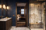 Experience luxury in this master bathroom featuring a spacious walk-in shower with marble tile and a built-in bench.