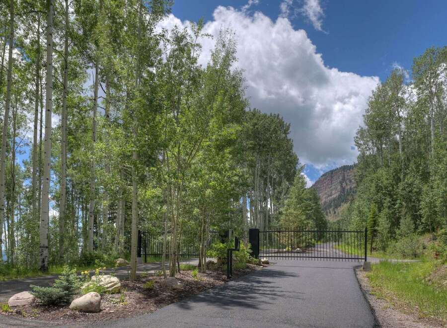 Discover the tranquility of this stunning property, nestled amidst lush greenery and towering trees.
