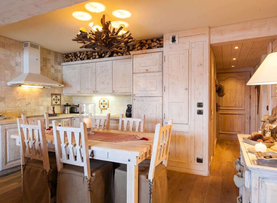 This stunning kitchen boasts a rustic charm with its wooden cabinets and a unique chandelier.