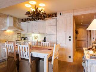 This stunning kitchen boasts a rustic charm with its wooden cabinets and a unique chandelier.