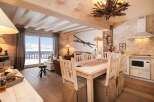This charming chalet-style interior showcases a cozy living space with rustic wooden beams and flooring.