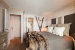 This cozy bedroom features a rustic design with wooden accents and a luxurious fur throw.