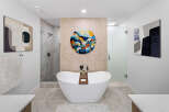 Step into luxury with this stunning bathroom, featuring a modern freestanding tub and a separate glass-enclosed shower.