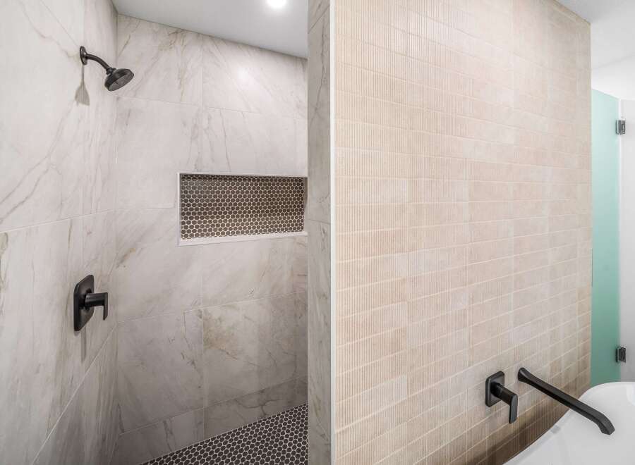 Step into luxury with this stunning bathroom featuring exquisite tile work and modern fixtures.