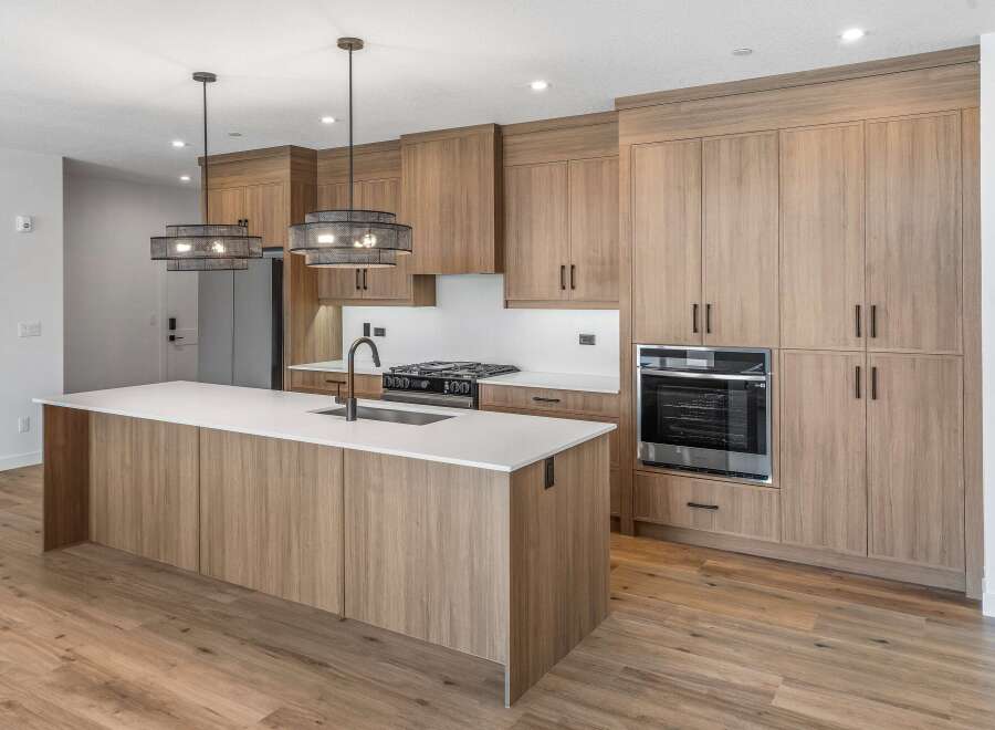 This stunning kitchen boasts modern design with sleek wooden cabinetry and a spacious island.