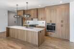 This stunning kitchen boasts modern design with sleek wooden cabinetry and a spacious island.