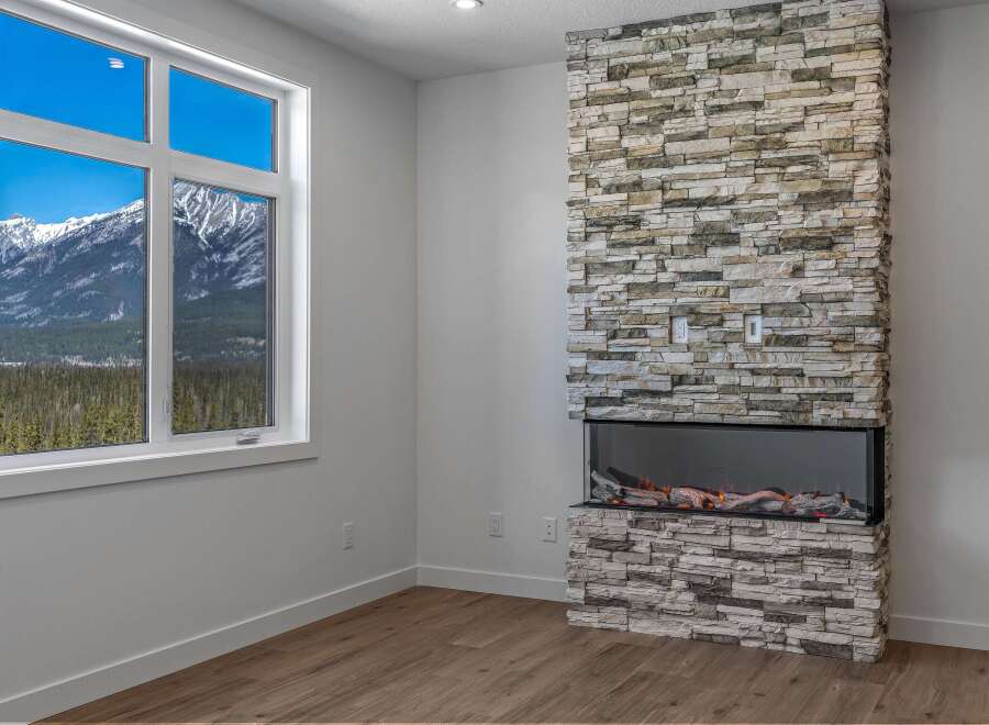 This stunning property boasts a modern fireplace with a stone facade, creating a cozy and inviting atmosphere.