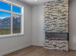 This stunning property boasts a modern fireplace with a stone facade, creating a cozy and inviting atmosphere.