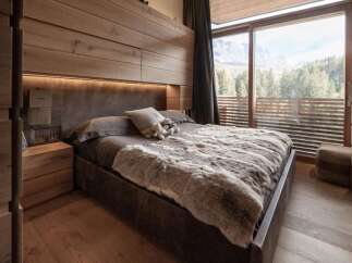 Experience luxury in this stunning bedroom featuring a plush, fur-like blanket and a cozy, inviting atmosphere.