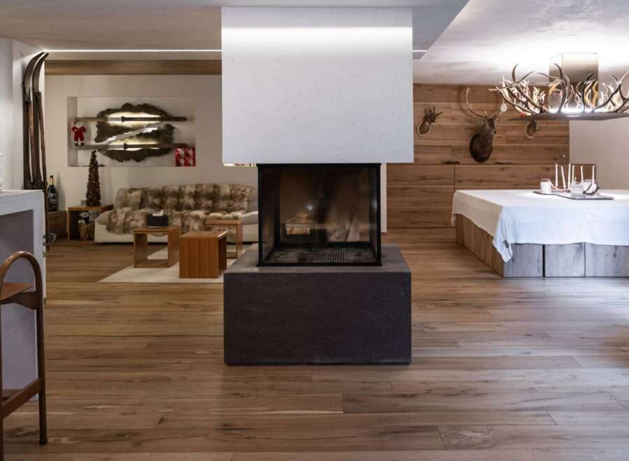 Experience rustic elegance in this stunning property, featuring a modern fireplace as the centerpiece.
