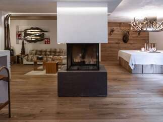 Experience rustic elegance in this stunning property, featuring a modern fireplace as the centerpiece.