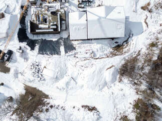 This stunning property boasts a modern design with a snow-covered roof, perfect for winter enthusiasts.