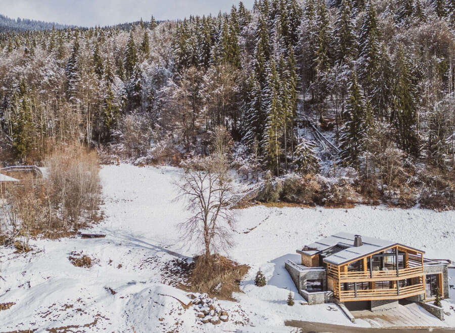 Nestled in a serene winter wonderland, this stunning property offers a luxurious escape.