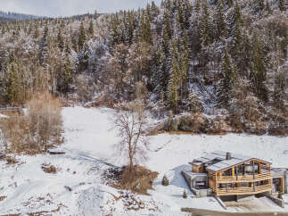 Nestled in a serene winter wonderland, this stunning property offers a luxurious escape.