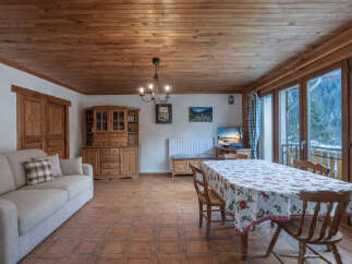 Step into this charming living space, featuring a warm wooden ceiling and inviting ambiance.