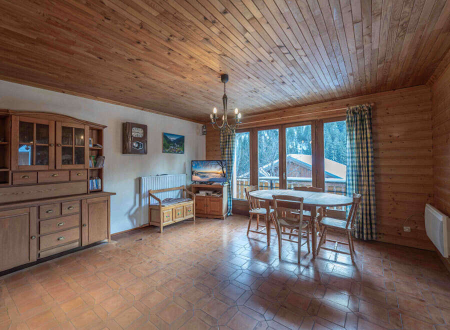 This charming property features a cozy living space with wooden paneling and a warm, inviting atmosphere.